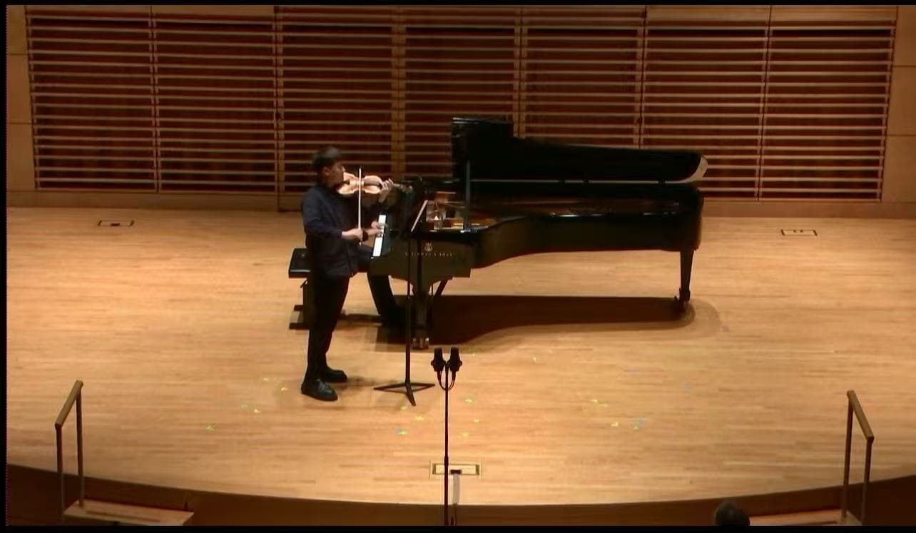 Ruoyao Li performing violin with piano on a concert stage