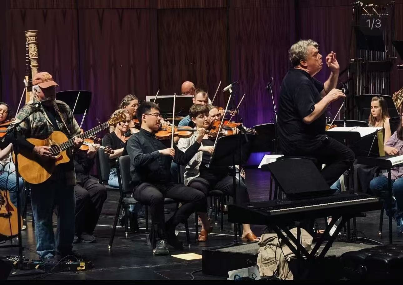 Ruoyao Li performing violin in an orchestra rehearsal setting